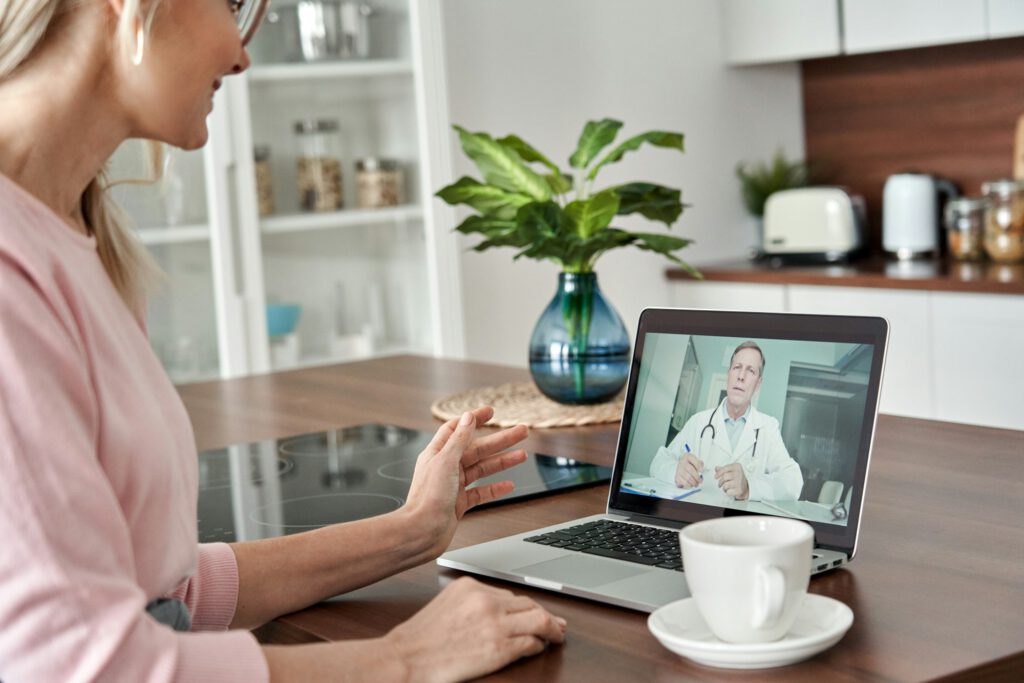 Middle aged female patient getting online telemedicine consultation at home.
